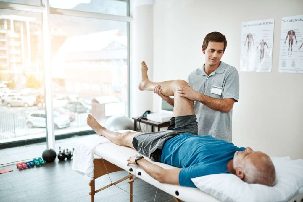 stretching-legs-mature-man-physiotherapist-with-fitness-clinic-physical-therapy-support-mobility-exercise-health-male-doctor-patient-help-muscle-recovery-rehabilitation (1)
